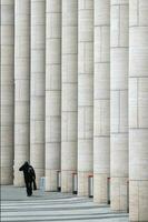 Silhouette von ein Mann beim das Marmor Vertikale Säulen von ein modern Geschäft Center. foto