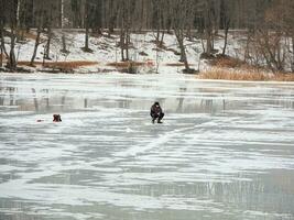 gefährlich Angeln auf nass Frühling Eis. Fischer auf nass schmelzen Eis. foto