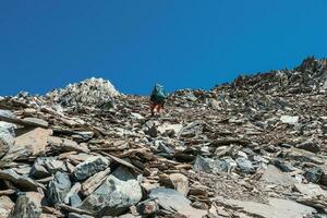 schwer Klettern auf ein steil Stein Neigung. Solo Trekking im das Berge. Reise Fotograf Lebensstil, Wandern schwer Schiene, Abenteuer Konzept im Frühling Urlaub. foto