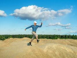 ein heiter Mann springt auf das Hügel foto