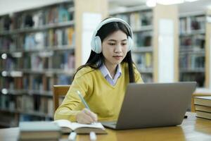 Schüler studieren beim Bibliothek mit Laptop. foto