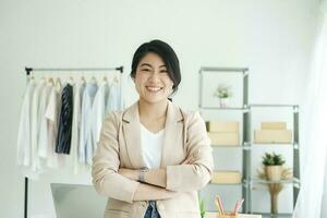 glücklich jung asiatisch weiblich Freelan Stehen im online Kleidung speichern. foto