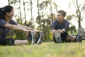 jung Mann und Frau Dehnen im das Park. foto