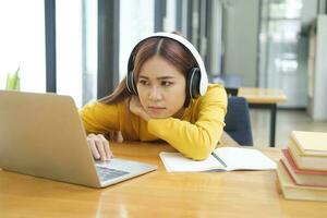 Frau müde und gelangweilt von Arbeiten oder Lernen online. foto
