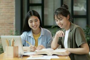 jung asiatisch Studenten Campus hilft Freund fangen oben und Lernen. foto
