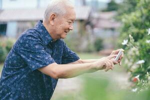 glücklich asiatisch Senior Mann nehmen ein Bild mit Handy, Mobiltelefon Telefon. foto