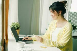 Frau mit Laptop und Anerkennung Karte zum online Einkaufen. foto