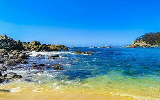 Strand Sand Blau Türkis Wasser Wellen Felsen Panorama puerto escondido. foto