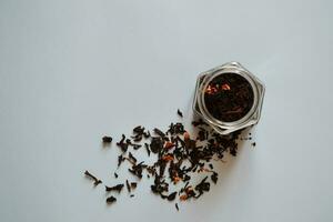 Blatt Tee mit Stücke von Obst im ein Krug, schwarz Tee, ein Krug von Tee auf ein grau Hintergrund, International Tee Tag, Banner foto