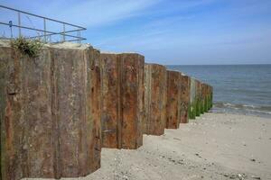 hölzern Bretter auf das sandig Strand im das Watte Meer foto