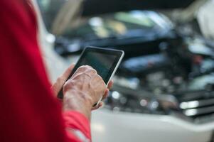 Nahansicht Techniker Mann Hand mit Tablette Analysieren Auto Probleme im Auto Reparatur Geschäft . Konzept von Auto Reparatur und Instandhaltung Service. foto