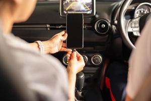 Frau, die Batterie Smartphone im Auto auflädt
