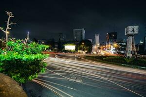 ho Chi minh Stadt, Vietnam - - apr 14, 2023 der Verkehr Marmelade beim sterben bien phu Kreisel mit es ist viergesichtig Uhr Turm ein Symbol von ho Chi minh Stadt. Licht Weg von Autos. foto