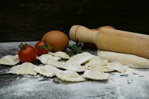 rollen Stift mit Tomaten, Teig, Eier, Mehl und Ravioli foto