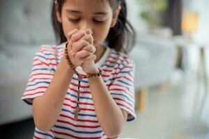 Christian Konzept. wenig asiatisch Mädchen beten Zurückhalten das Kreuz. Konzepte von Hoffnung, Glaube, Christentum, Religion, foto
