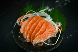 frisch roh Lachs Fisch zum Kochen Essen Meeresfrüchte Lachs Fisch, Lachs Sashimi Essen Lachs Filet japanisch Speisekarte mit Shiso Perilla Blatt Zitrone Kraut und Gewürze foto