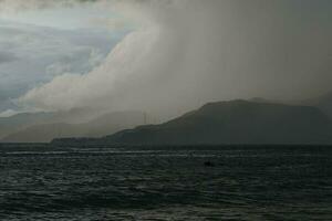 Sturm Über das Meer mit Berge im das Hintergrund foto