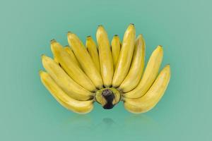 Gruppe von reifen Bananen der gelben Farbe lokalisiert auf grünem Farbhintergrund foto