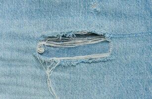 Fragment von Blau Jeans Stoff mit ein Loch, voll rahmen, schließen oben foto