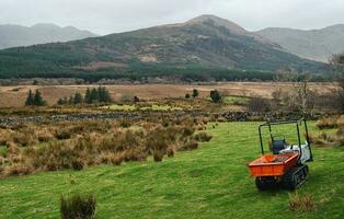 schön ländlich Landschaft Landschaft mit Maschinen auf das Grün Wiese umgeben durch Berge beim connemara National Park, Bezirk Galway, Irland foto