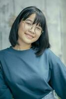 Porträt von asiatisch Teenager lächelnd mit Glück tragen beiläufig Kleider foto