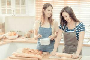 zwei kaukasisch Frauen Kochen Pizza zusammen im das Küche. das Konzept von Zuhause gekocht Essen und lgbt Beziehungen. Familie und Vielfalt Konzept. lgbt Liebe. warm Ton foto