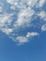 weiße Wolken am blauen Himmel. schöner hellblauer Hintergrund. leicht bewölkt, gutes Wetter. lockige Wolken an einem sonnigen Tag. foto