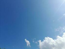 weiße Wolken am blauen Himmel. schöner hellblauer Hintergrund. leicht bewölkt, gutes Wetter. lockige Wolken an einem sonnigen Tag. foto