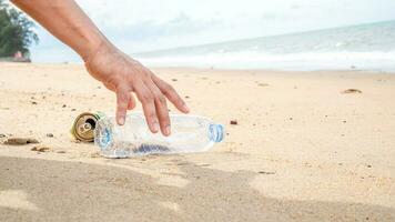 Hand pflücken oben Plastik Flasche Reinigung auf das Strand. speichern das Welt Konzept. Umfeld, Ökologie Pflege, verlängerbar Konzept, Natur Erhaltung Tourismus foto