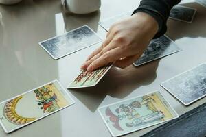 Twer, Russland - - Februar 11, 2023. Tarot Karten, Tarot Karte Divination, esoterisch Hintergrund. ein Frau macht ein Layout auf das Karten beim das Tisch. Divination, Vorhersagen auf Tarot Karten. foto