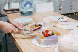 Schneiden ein Schokolade Mousse Kuchen auf das Tisch. Vorbereitung von Mousse Kuchen beim ein kulinarisch Meister Klasse. Kochen beim heim, hausgemacht Essen foto