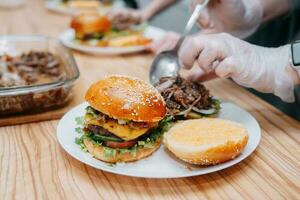 Burger mit Rindfleisch und Gemüse. schließen hoch. köstlich Burger im ein Kochen Klasse. Burger mit Cranberry Soße und Burger mit Zwiebel Soße. foto