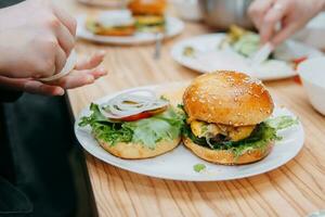 Burger mit Rindfleisch und Gemüse. schließen hoch. köstlich Burger im ein Kochen Klasse. Burger mit Cranberry Soße und Burger mit Zwiebel Soße. foto