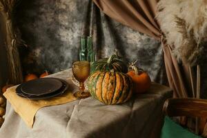 Herbst Innere. ein Tabelle bedeckt mit Teller, Kürbisse, Stuhl, beiläufig Anordnung von japanisch Pampas Gras. Innere im das Foto Studio.