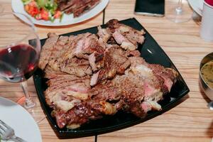 Rindfleisch Steak mit Grüns auf ein schwarz Platte. Steak mit Basilikum gekocht im das kulinarisch Meister Klasse foto