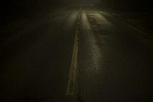 Straße beim Nacht im Nebel. Nebel auf schosse. schwach Licht auf Straße im dunkel. foto