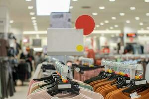selektiv Fokus zu leer Weiß Tafel zum Damen und Herren Kleidung Rabatt Vorlage im Einkaufszentrum. Sanft Fokus foto
