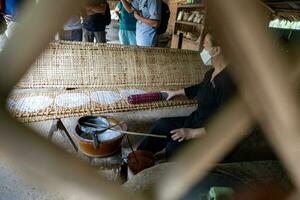 frisch gemacht Reis Papier ist Trocknen auf Bambus Tabelle zum Produktion von Knödel und Frühling Rollen im das cu Chi Tunnel. berühmt Tourist Attraktion im Vietnam. Lager Foto