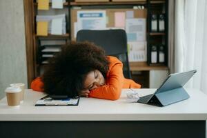 afrikanisch Geschäft Frau ist betont, gelangweilt, und überdenken von Arbeiten auf ein Tablette beim das Büro. foto