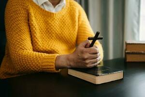 Hände zusammen im Gebet zu Gott zusammen mit der Bibel im christlichen Konzept und in der Religion, Frau betet in der Bibel auf dem Holztisch foto