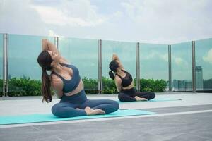 schlanke Frau, die Yoga auf dem Balkon ihrer Eigentumswohnung praktiziert. asiatische frau, die morgens übungen macht. balance, meditation, entspannung, ruhe, gute gesundheit, glücklich, entspannen, gesundes lebensstilkonzept foto