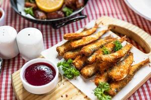 Kilka, Sprottenfisch, Ketchup und andere Snacks aus der Nähe foto