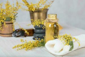 Mimose Blumen Massage Öl im Glas Flasche. foto