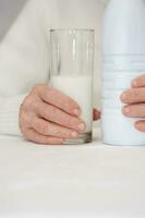 Senior Frau und ein Glas von Milch. foto