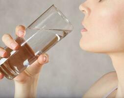 jung kaukasisch Dame mit ein Glas von Wasser Nahansicht foto