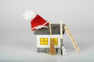 klein handgemacht Papier Haus und Santa claus Hut auf Es. foto