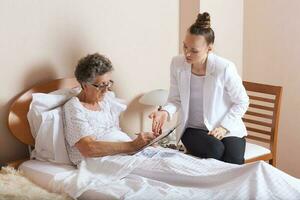 Besuch von Senior Sozial Arbeit Assistent zu ein alt Frau foto