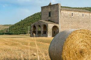 Navelli, Italien-August 9, 2021-Ansicht von das Kirche von das Madonna del campo im das öffnen Landschaft während ein sonnig Tag foto