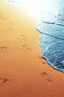 am Strand spazieren gehen, Fußspuren im Sand hinterlassen. foto