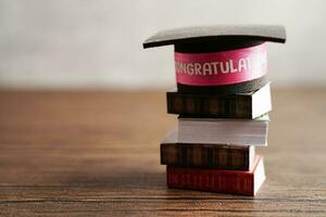 Abschluss Hut auf Buch mit Kopieren Raum, Lernen Universität Bildung Konzept. foto